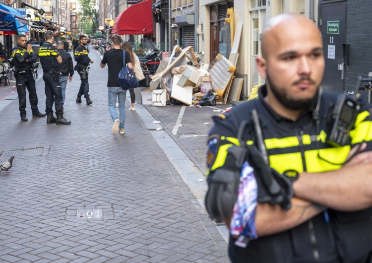 Reporter kryminalny Peter R. de Vries został postrzelony we wtorek w Amsterdamie. Nz. policjant pilnujący miejsca zdarzenia.  Reporter kryminalny postrzelony w Amsterdamie. Oddano pięć strzałów, dziennikarz walczy o życie