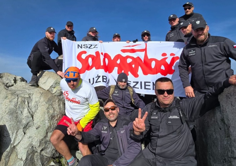 Funkcjonariusze SW z flagą 45-lecia NSZZ