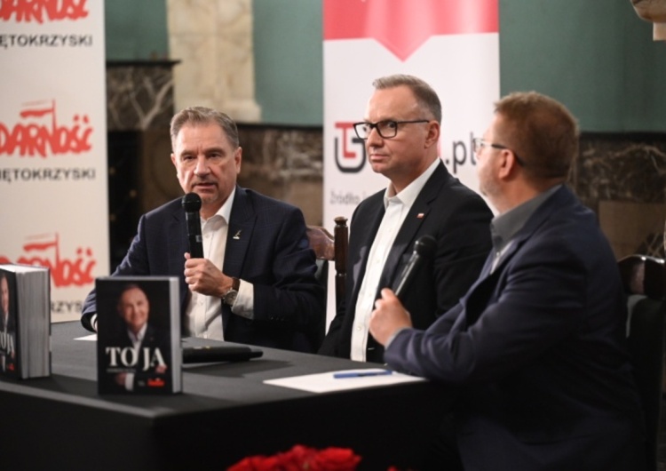 Trzech mężczyzn przy stole z postawionymi książkami Red. Naczelny 