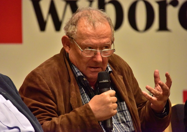 Adam Michnik na tle logo Gazety Wyborczej 